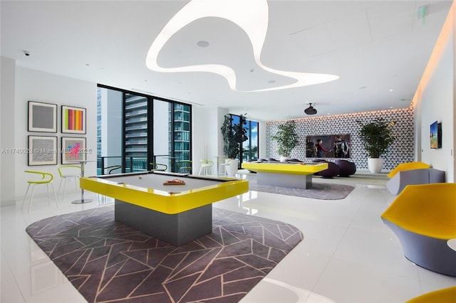 playroom with a wall of windows, billiards, and dark tile patterned floors