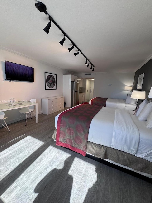 bedroom featuring stainless steel refrigerator and hardwood / wood-style floors