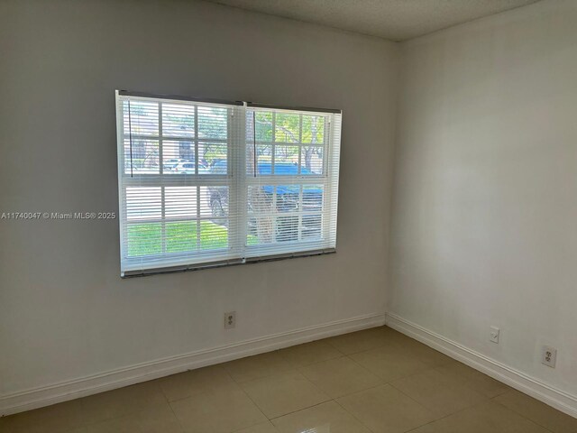 620 Cypress Club Way Unit I13, Deerfield Beach, FL 33064 - spare room with baseboards and light tile patterned floors