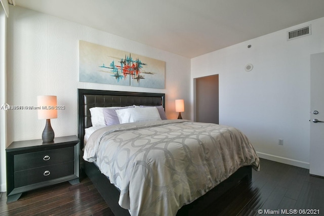 bedroom with dark hardwood / wood-style flooring