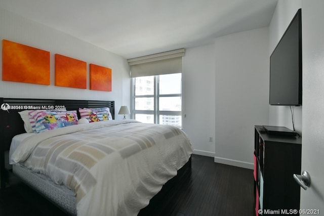 bedroom with dark hardwood / wood-style floors