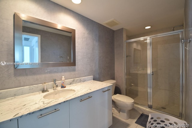 bathroom featuring vanity, tile patterned floors, toilet, and walk in shower