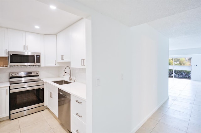 kitchen featuring stainless steel appliances, tasteful backsplash, sink, and white cabinets