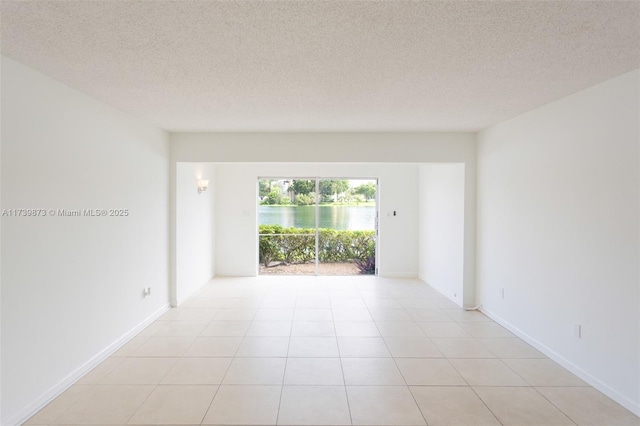 tiled spare room with a textured ceiling