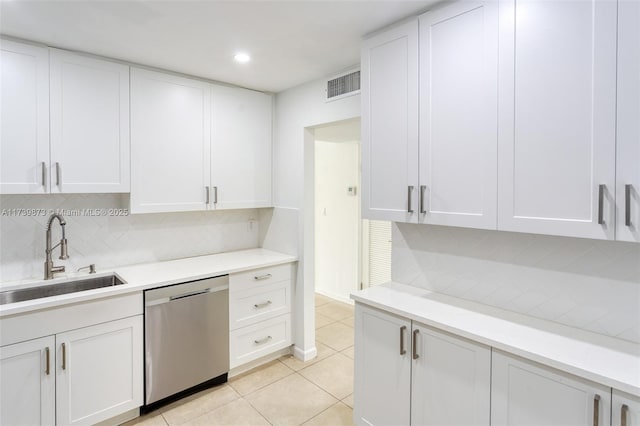 kitchen featuring white cabinetry, sink, decorative backsplash, stainless steel dishwasher, and light tile patterned floors