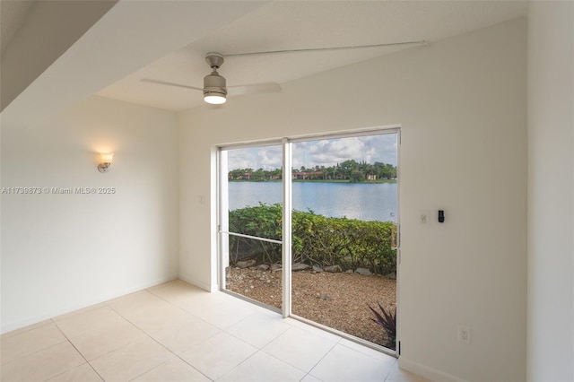 unfurnished dining area with a water view, ceiling fan, and light tile patterned flooring