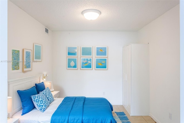 tiled bedroom featuring a textured ceiling