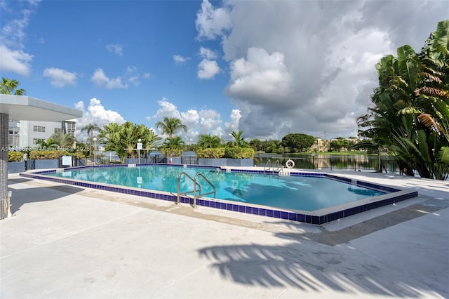 view of pool featuring a patio and a water view