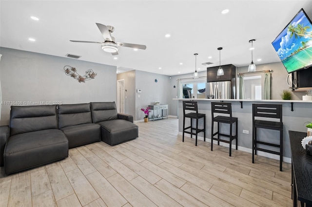 living room featuring ceiling fan and light hardwood / wood-style floors