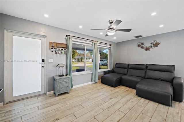 living room with ceiling fan and light wood-type flooring