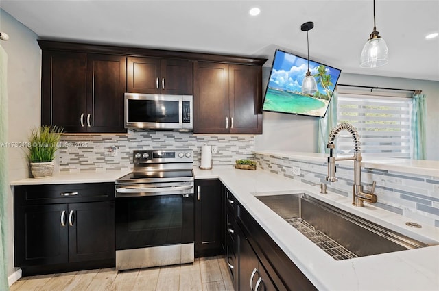 kitchen featuring pendant lighting, sink, backsplash, stainless steel appliances, and dark brown cabinets