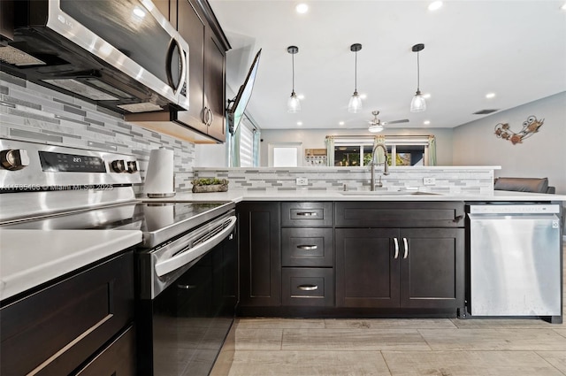 kitchen with tasteful backsplash, sink, hanging light fixtures, dark brown cabinetry, and stainless steel appliances