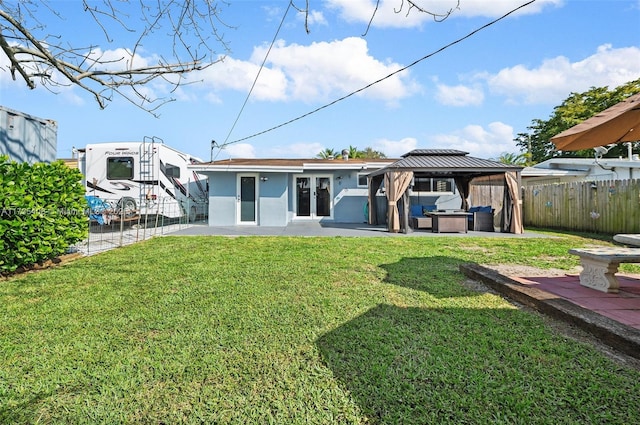 rear view of property with a gazebo, a yard, and a patio