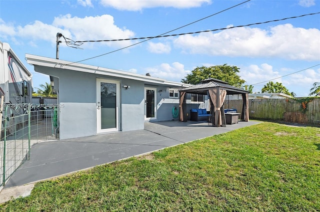 rear view of house featuring a gazebo, outdoor lounge area, a patio, and a lawn