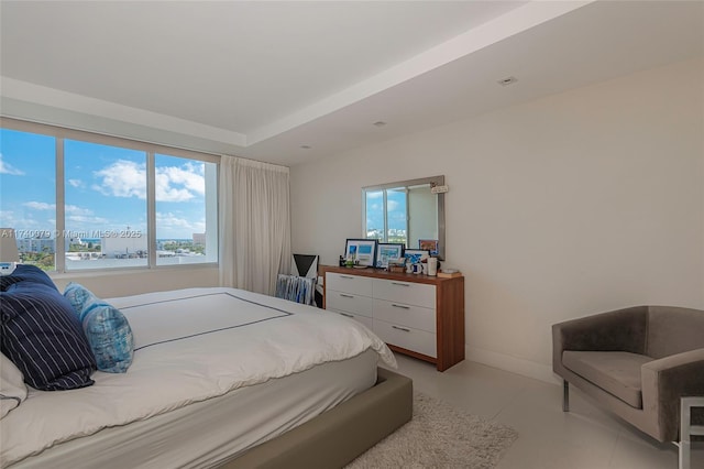 bedroom featuring multiple windows and a tray ceiling