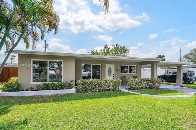 view of front of home with a carport and a front lawn