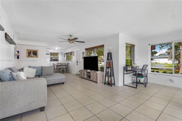 living room featuring light tile patterned flooring, plenty of natural light, ceiling fan, and crown molding