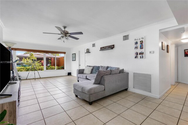 living room featuring ceiling fan, ornamental molding, and light tile patterned floors