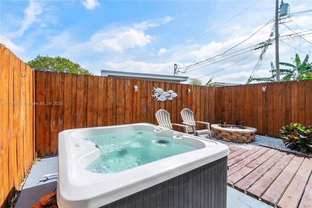 wooden terrace featuring a fire pit and a hot tub