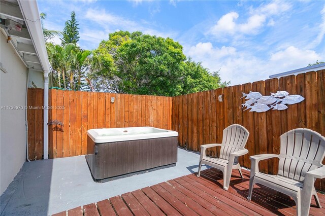 wooden deck featuring a hot tub