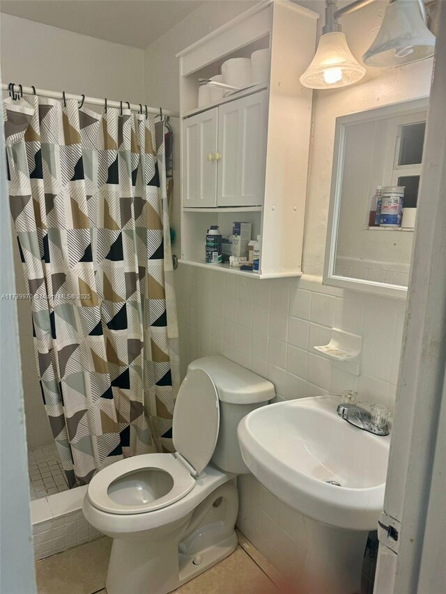 bathroom featuring sink, tile walls, backsplash, walk in shower, and toilet