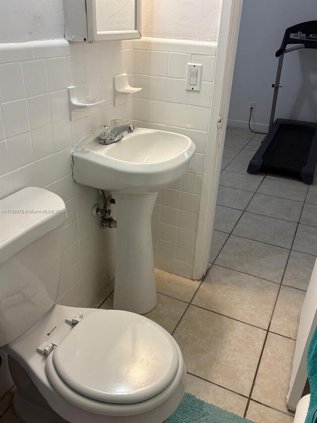 bathroom featuring tile walls, tile patterned floors, and toilet