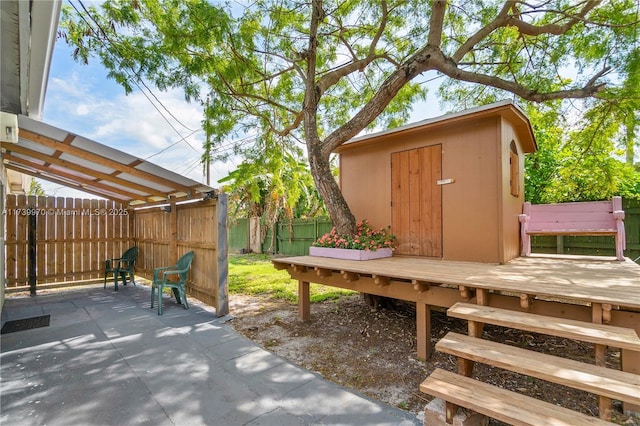 view of patio / terrace with a wooden deck and a storage shed