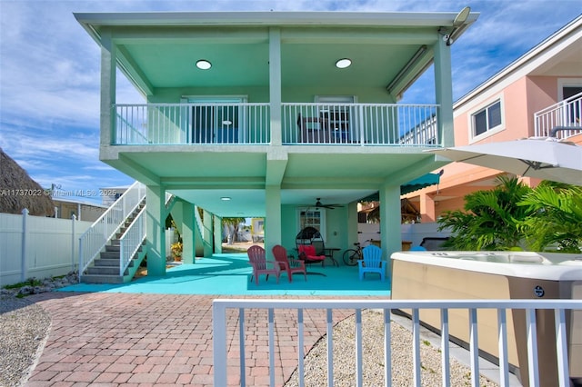 rear view of property featuring a hot tub, a patio, and ceiling fan