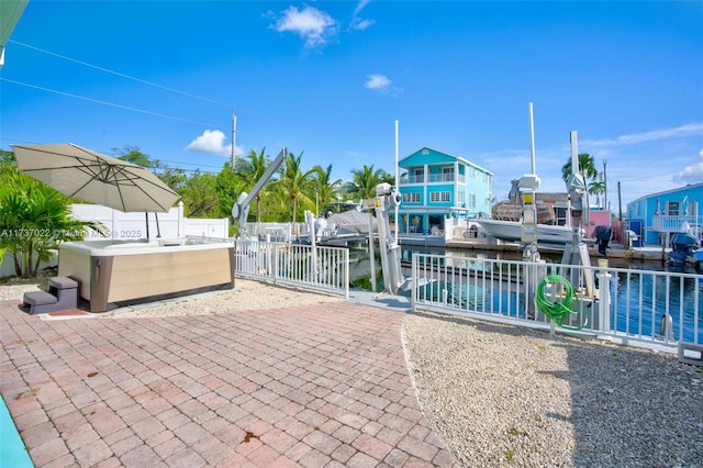 view of patio with a water view and a jacuzzi