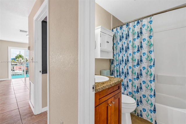 full bathroom with tile patterned flooring, vanity, shower / tub combo, and toilet