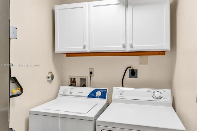 washroom with cabinets and washer and dryer