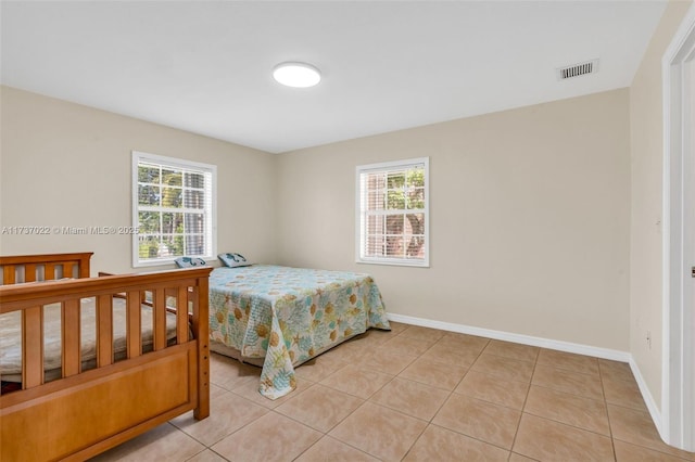 bedroom with multiple windows and light tile patterned floors