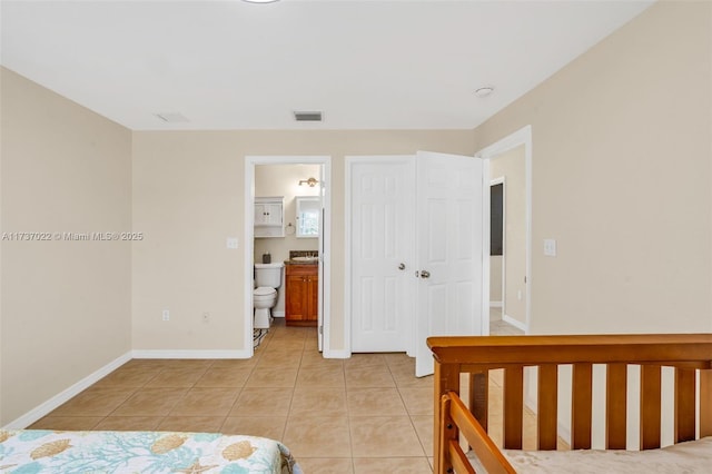 unfurnished bedroom featuring light tile patterned floors and ensuite bath