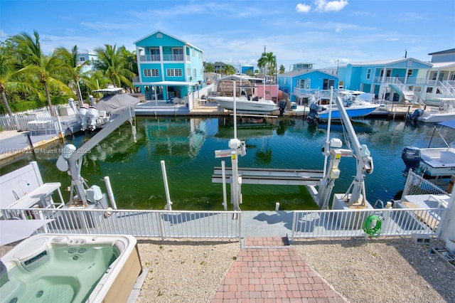 view of dock featuring a water view and an outdoor hot tub