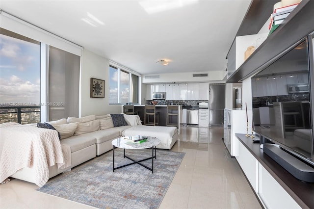 living room with expansive windows and light tile patterned floors