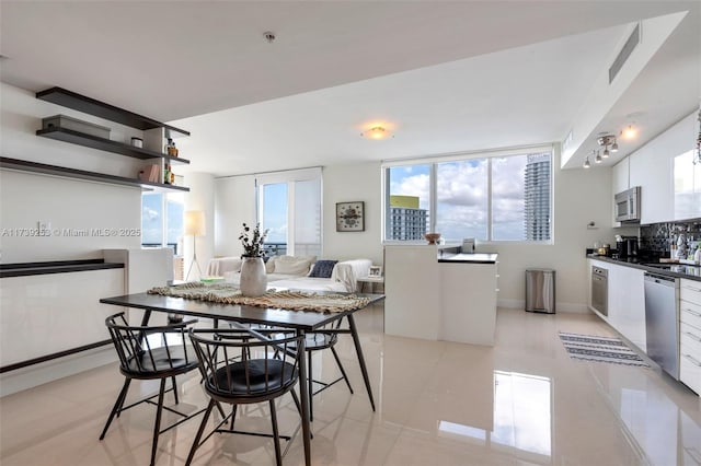 kitchen featuring light tile patterned flooring, sink, white cabinetry, tasteful backsplash, and stainless steel appliances