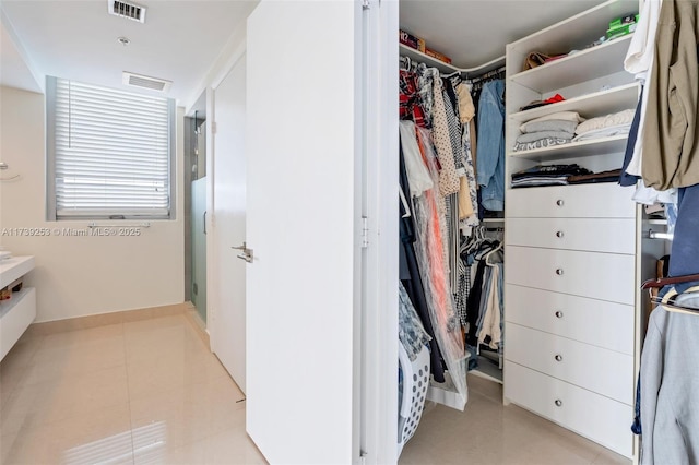 walk in closet featuring light tile patterned flooring