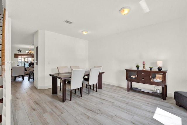 dining area featuring a notable chandelier and light hardwood / wood-style flooring