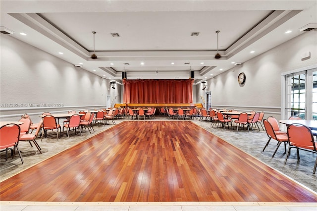 interior space with a tray ceiling and light hardwood / wood-style floors