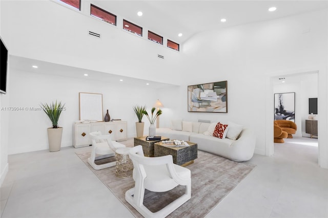 living area with a towering ceiling and recessed lighting