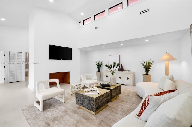 living room featuring recessed lighting, visible vents, and a towering ceiling