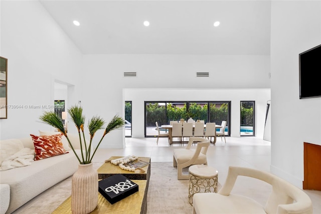 living room featuring plenty of natural light, a high ceiling, and visible vents