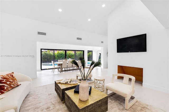 living area featuring a high ceiling, visible vents, and recessed lighting