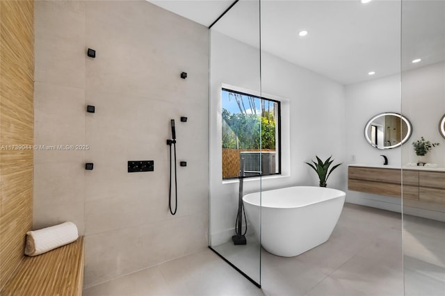 full bathroom featuring tile patterned flooring, vanity, a freestanding tub, a walk in shower, and recessed lighting