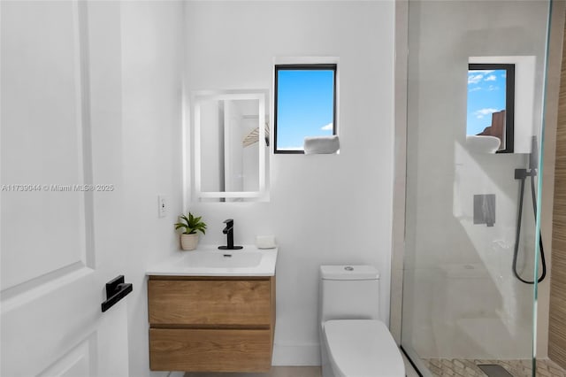 bathroom with a stall shower, vanity, and toilet