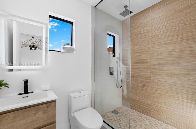 full bathroom with a stall shower, vanity, and toilet