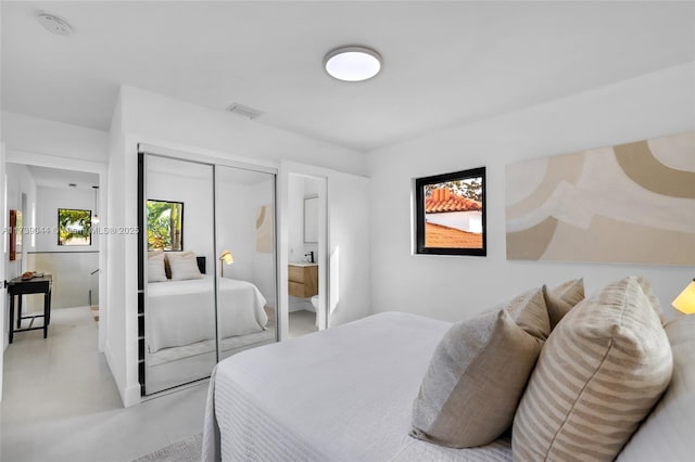 bedroom featuring concrete flooring, a closet, and visible vents