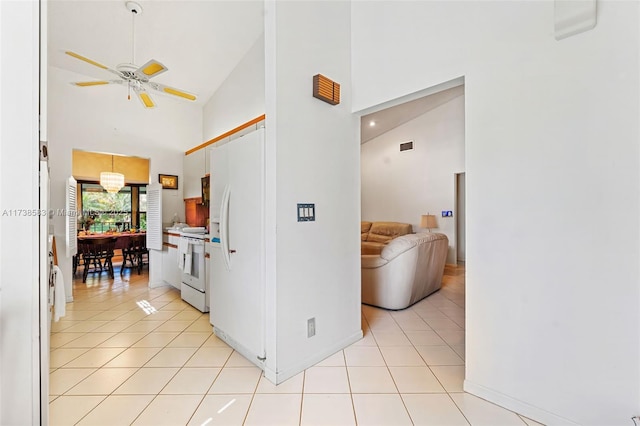 hall with light tile patterned floors and high vaulted ceiling