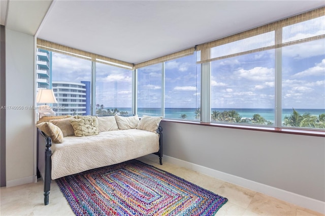 bedroom with a water view and baseboards