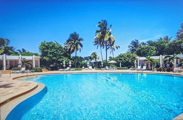 community pool featuring fence and a patio